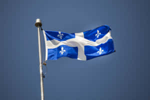 Quebec Fleurdelis Flag Against Blue Sky Wallpaper