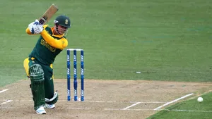 Quinton De Kock Kneeling On The Cricket Field Wallpaper