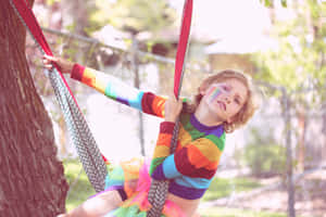 Rainbow Child Swinging Outdoors Wallpaper