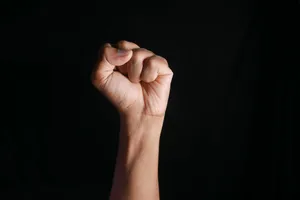 Raised Fist Against Black Background Wallpaper