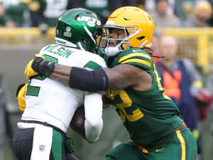 Rashan Gary Tackling Opponent During Game Wallpaper