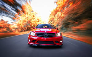 Red Amg Speeding Down The Road Wallpaper