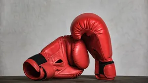 Red Boxing Gloves Restingon Wooden Surface Wallpaper