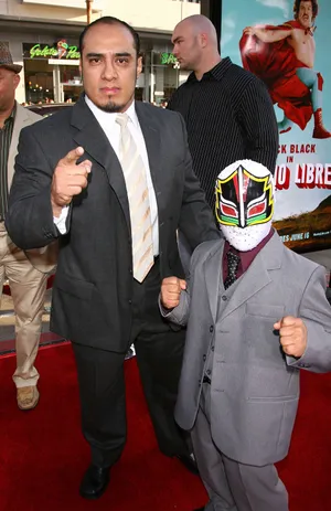 Red Carpet Event With Masked And Unmasked Men Wallpaper