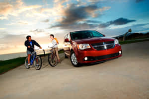 Red Dodge Grand Caravan Bicyclists Sunset Wallpaper