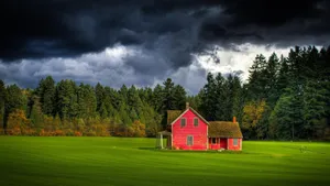 Red Farmhouse Under Stormy Skies Wallpaper
