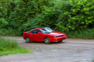 Red Isuzu Impulse Speedingon Dirt Road Wallpaper