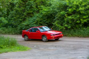 Red Isuzu Impulse Speedingon Dirt Road Wallpaper
