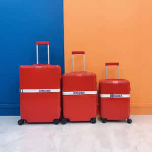 Red Rimowa Suitcases Blue Orange Background Wallpaper