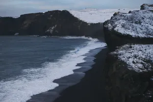 Relax And Let The Sea Breeze Wash Away Worry At This Stunning Black Sand Beach. Wallpaper