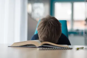 Reluctant Boy Sleeping On Book Wallpaper