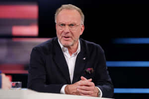 Renowned German Football Executive Karl-heinz Rummenigge Captured In Television Interview Wallpaper