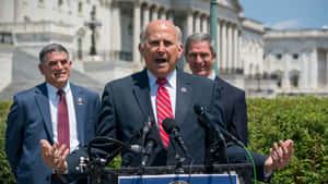 Representative Louie Gohmert Delivering A Speech Outside The Capitol Building Wallpaper