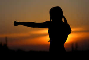 Resilient Woman Striking The Air Wallpaper