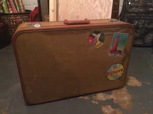 Retro Brown Suitcasewith Travel Stickers Wallpaper