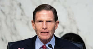 Richard Blumenthal In Front Of A Marble Backdrop Wallpaper