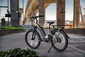 Rider On A Stylish Electric Bike On A Scenic Route Wallpaper