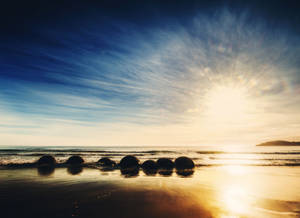 Rise With The Sun On Moeraki Boulders Beach Wallpaper