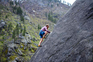 Rock Climber Ascending Steep Cliff Wallpaper