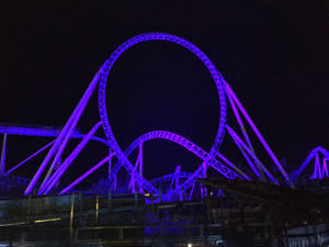 Roller Coaster In Neon Purple Color Wallpaper