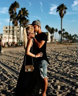 Romantic Couple Embracing On A Bridge Wallpaper