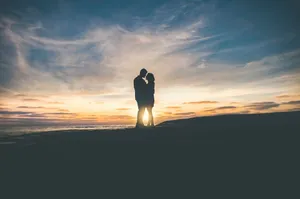 Romantic Silhouette Sunset Embrace Wallpaper