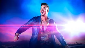 Romeo Santos Performing Under Stage Lights Wallpaper