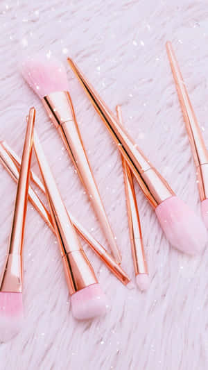 Rose Gold Makeup Brusheson Pink Background Wallpaper