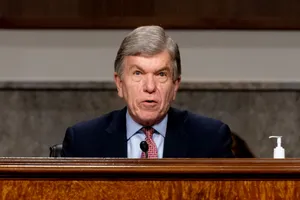 Roy Blunt Thoughtfully Observing From Behind A Ledge Wallpaper