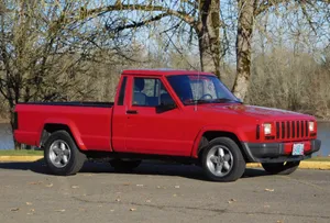 Rugged Beauty: A Jeep Comanche Perfectly Captured In Its Natural Environment Wallpaper