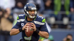 Russell Wilson Gripping Football Wallpaper