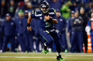 Russell Wilson Running In The Rain Wallpaper