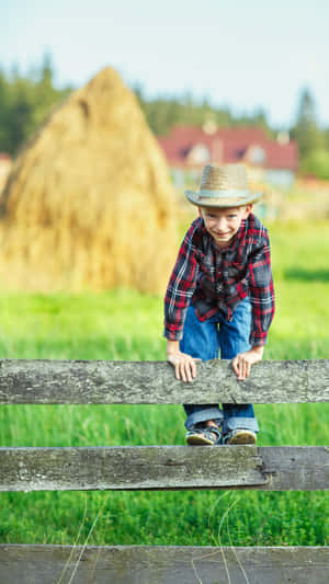 Rustic Farm Boy Leaningon Fence Wallpaper