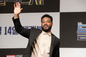 Ryan Coogler At An Event, Confidently Looking Into The Distance Wallpaper