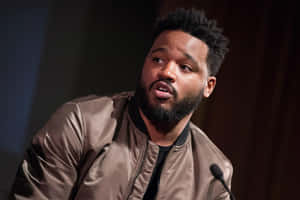 Ryan Coogler Standing In Front Of A Colorful Graffiti Wall Wallpaper