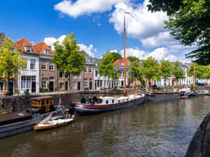 S Hertogenbosch Canal Viewwith Boatsand Houses Wallpaper