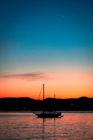 Sailing Against Vibrant Twilight Sky Wallpaper