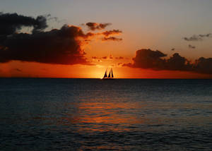 Sailing Sailboat On Ocean's Horizon Wallpaper