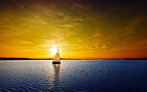 Sailing Under Orange-hued Skies Wallpaper