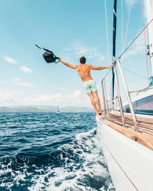 Sailing While Man Stands Outside Deck Wallpaper