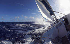 Sailing Yacht Braving Waves Wallpaper