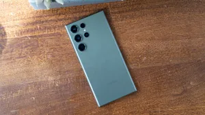 Samsung S23 Ultra Green Back Camera Array Wooden Surface Wallpaper