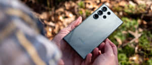 Samsung S23 Ultra In Hand Outdoors Wallpaper