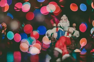 Santa Figurine And Colorful Christmas Lights Wallpaper