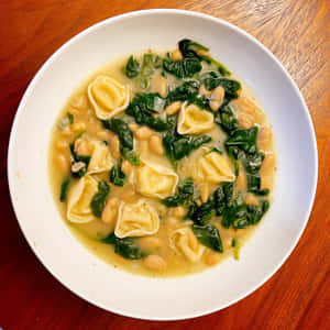 Savory Tortellini In Brodo With Spinach And Legumes Wallpaper