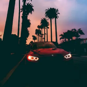 Scenic Sunset Drive Under An Orange Sky Wallpaper