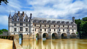 Scenic View Of Château De Chenonceau Over The Muddy River Wallpaper