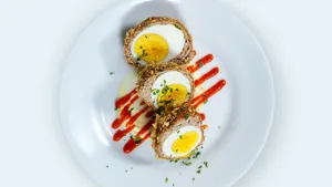 Scotch Eggs Dish With Red Sauce And Herbs Wallpaper