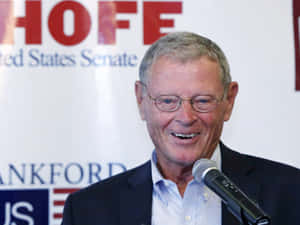 Senator Jim Inhofe Addressing The Media With A Microphone Wallpaper