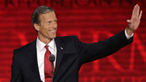 Senator John Thune Posed Against A Red Background Wallpaper